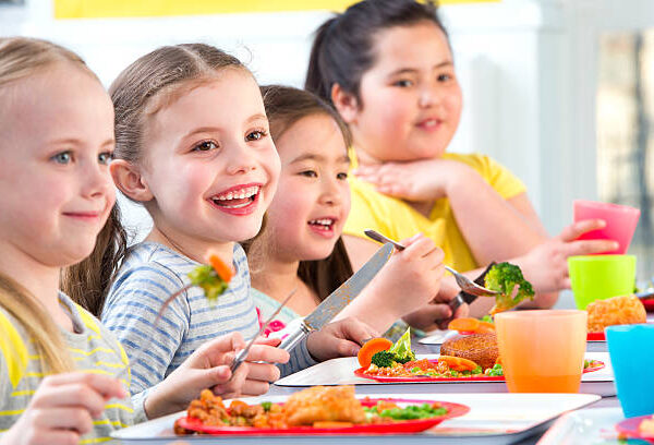 Happy school children enjoying their school dinners Happy school children enjoying their school dinners